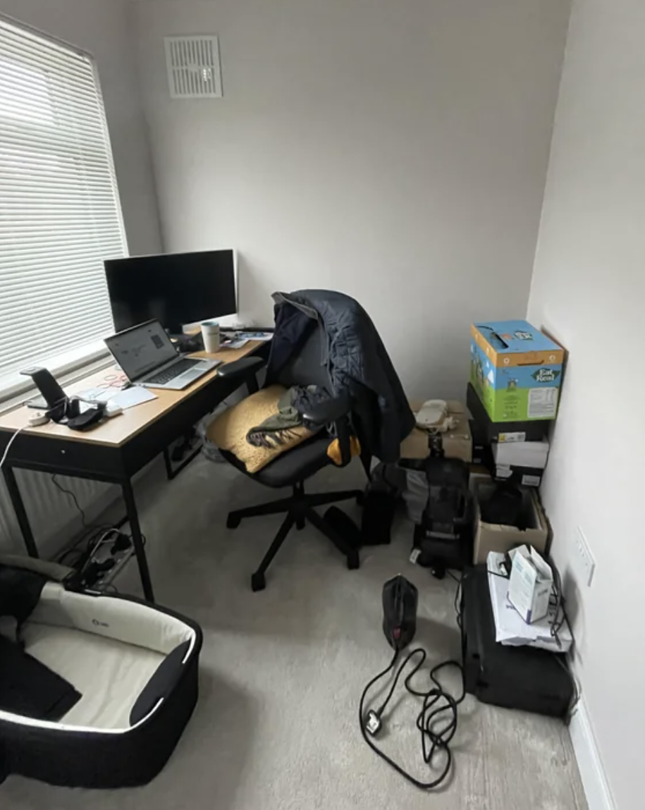 Home office with desk, computer, and shelving in a minimalistic setup