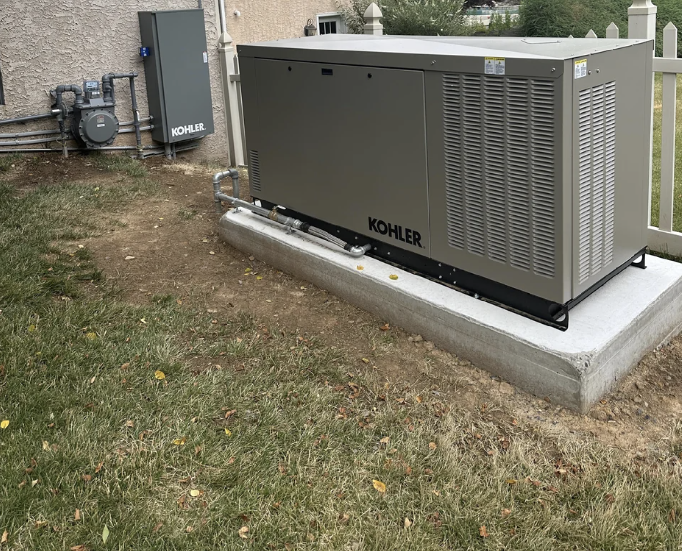 A newly installed generator beside a house with surrounding foliage