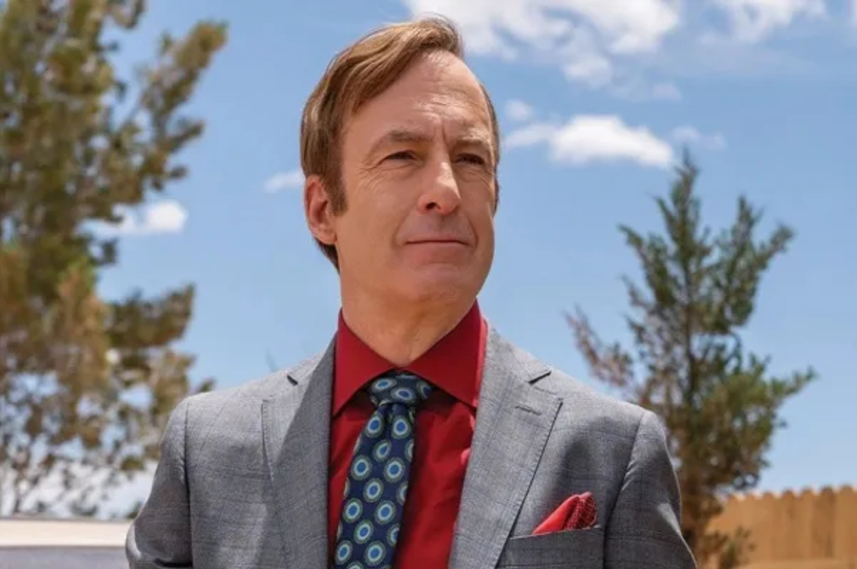Man in suit with tie and pocket square, outdoors, represents a TV character