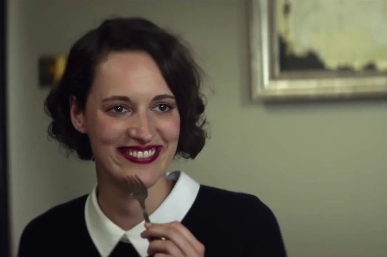 Phoebe Waller-Bridge in a scene from &quot;Fleabag&quot;, smiling with a fork near her mouth