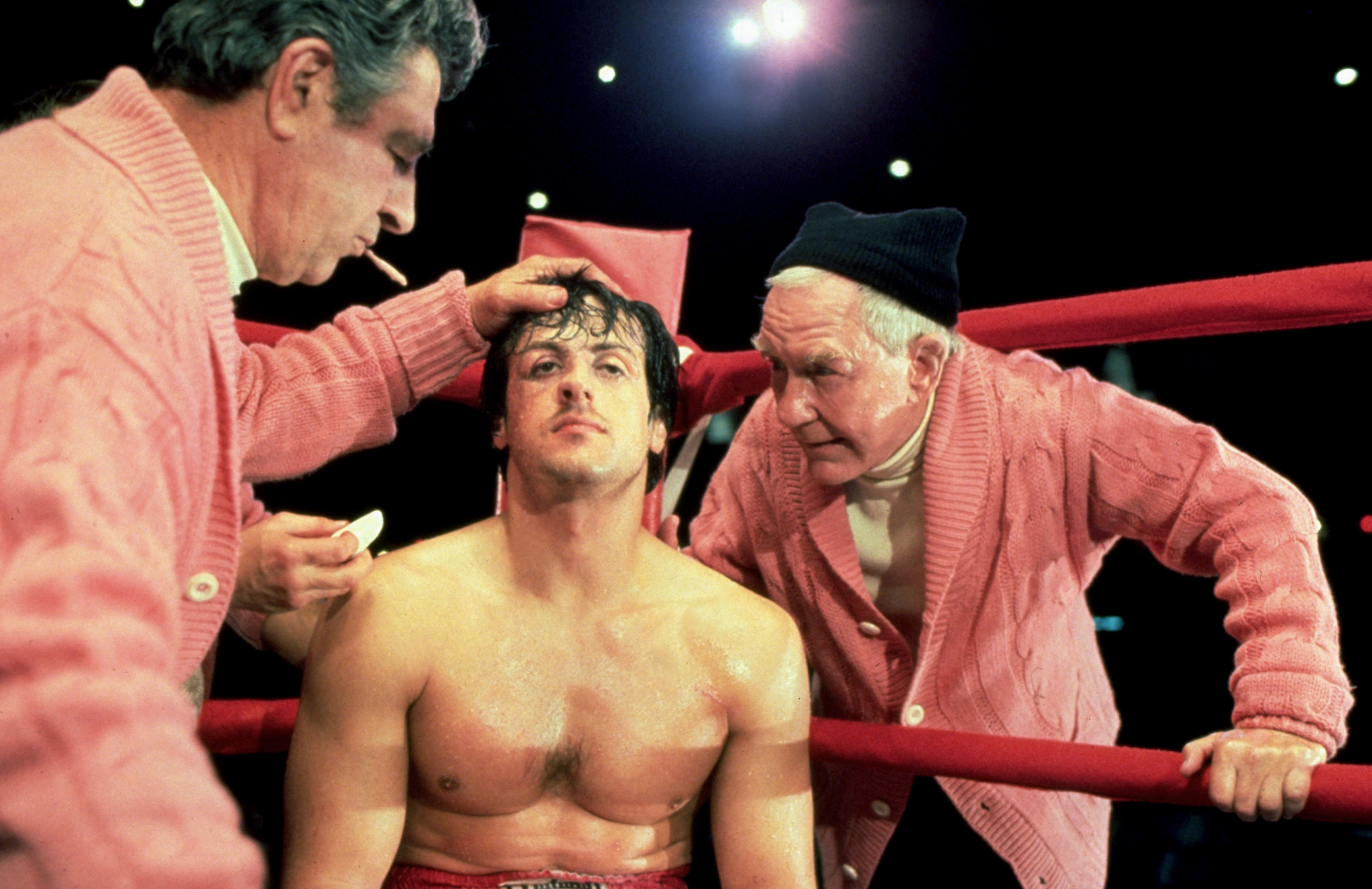 Sylvester Stallone as Rocky with trainer and cutman in boxing ring during a break in a match from the movie &quot;Rocky&quot;