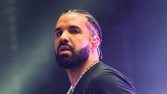 Drake in a close-up onstage, wearing a necklace and an earpiece