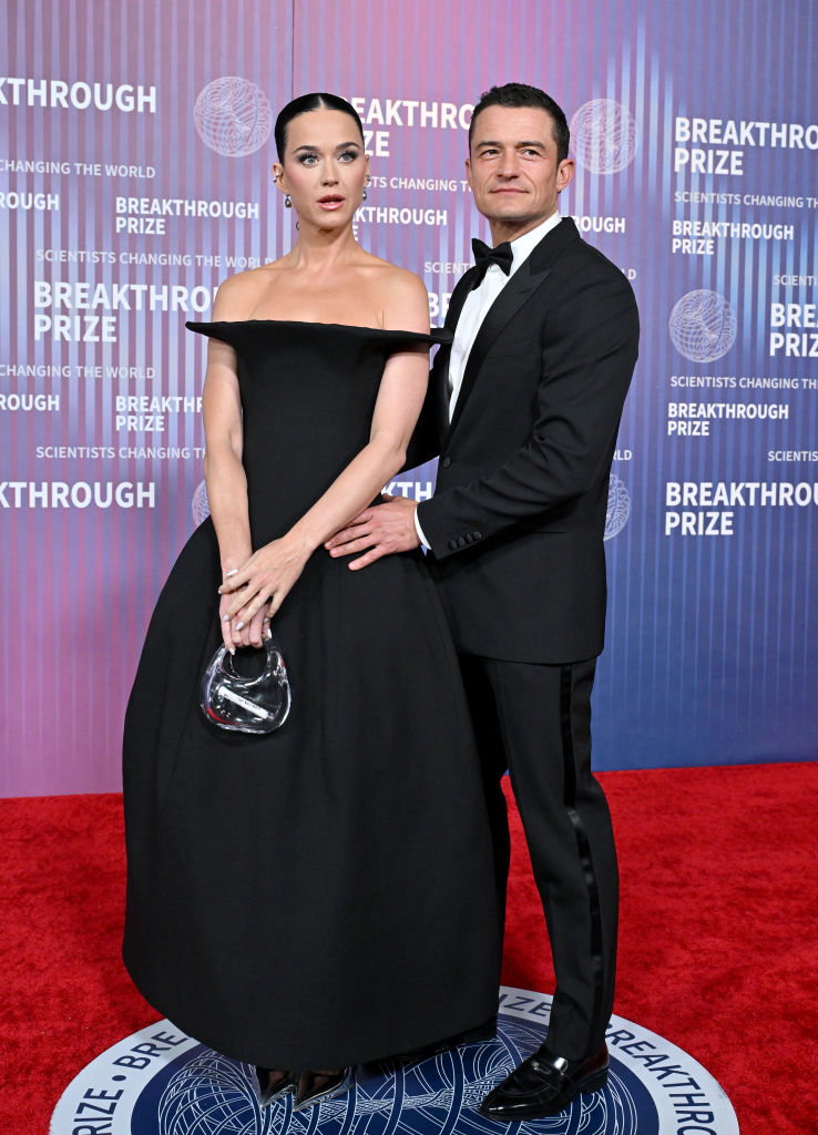 Katy Perry in a black off-the-shoulder gown and Orlando Bloom in a classic tuxedo pose at an event