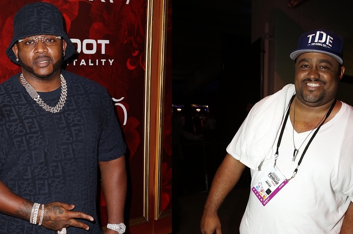 Two men at an event, left wearing a black durag and chain, right in a white tee and blue cap
