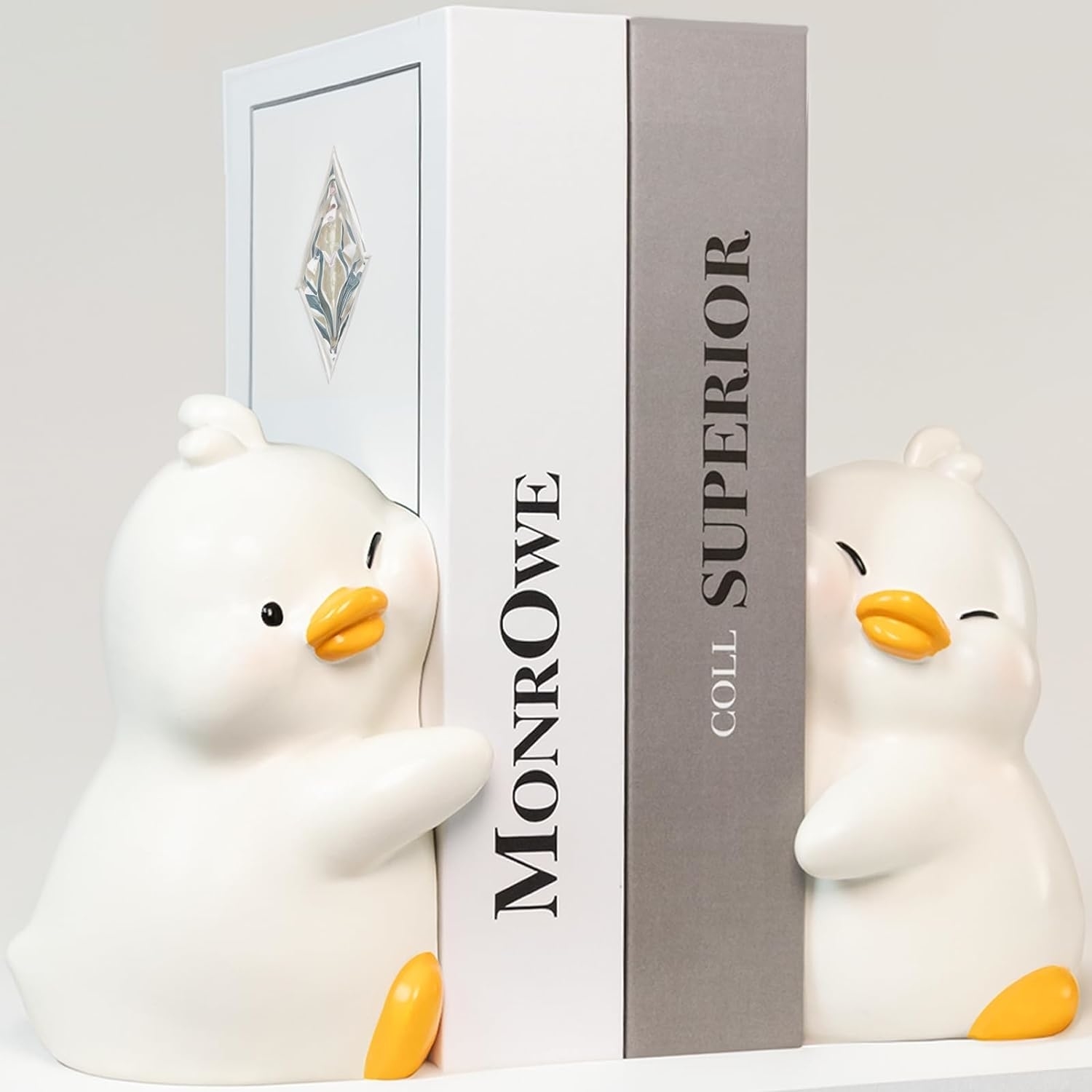 Two large duck book ends holding two books up