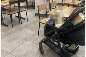 ベビーカーが飲食店内に置かれ、テーブルと椅子が背景にあります。