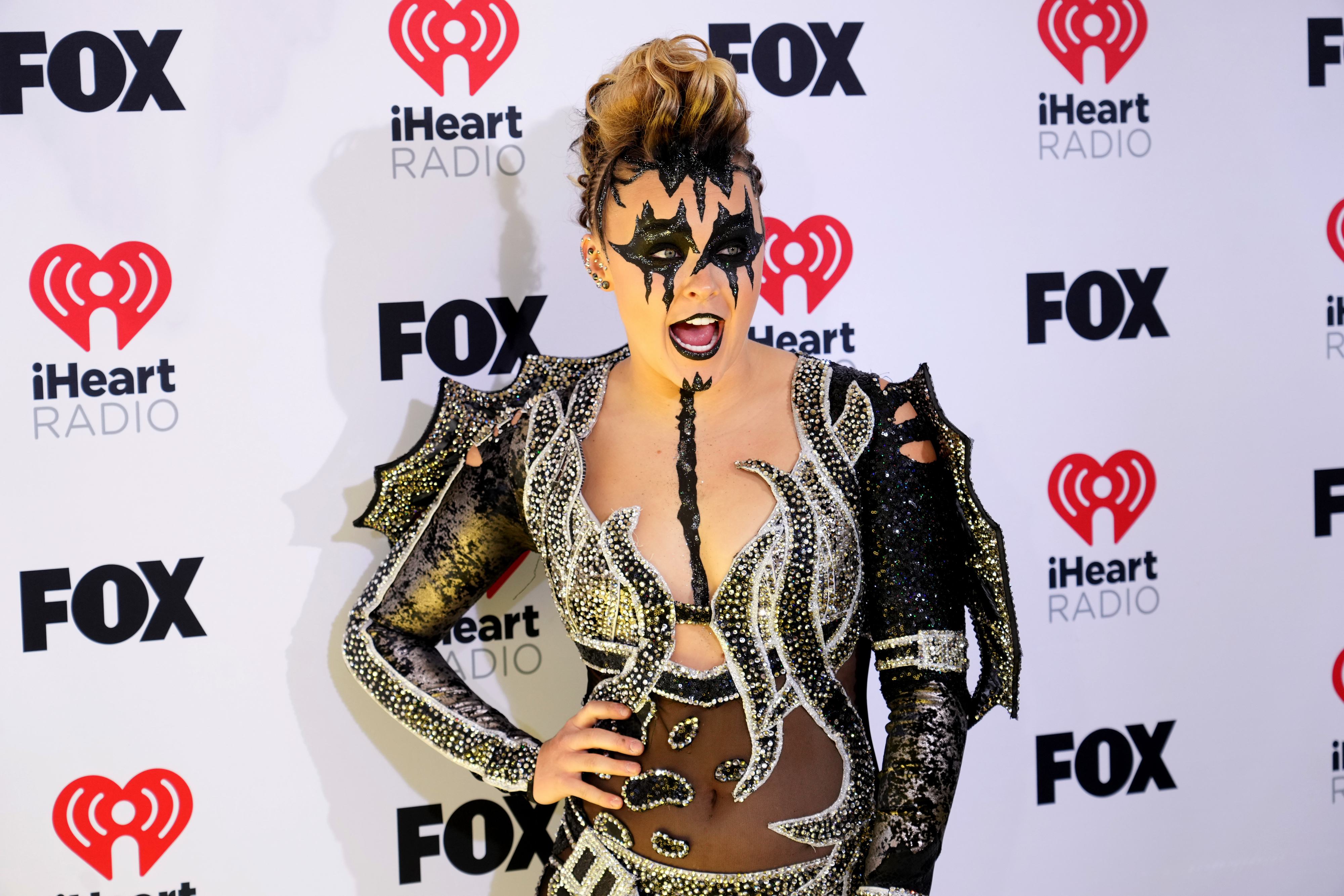 JoJo Siwa in an elaborate costume with face paint at the iHeartRadio event