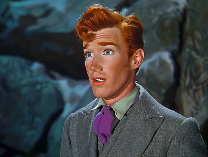 Animated character resembling a male with red hair, wearing a grey suit and purple necktie