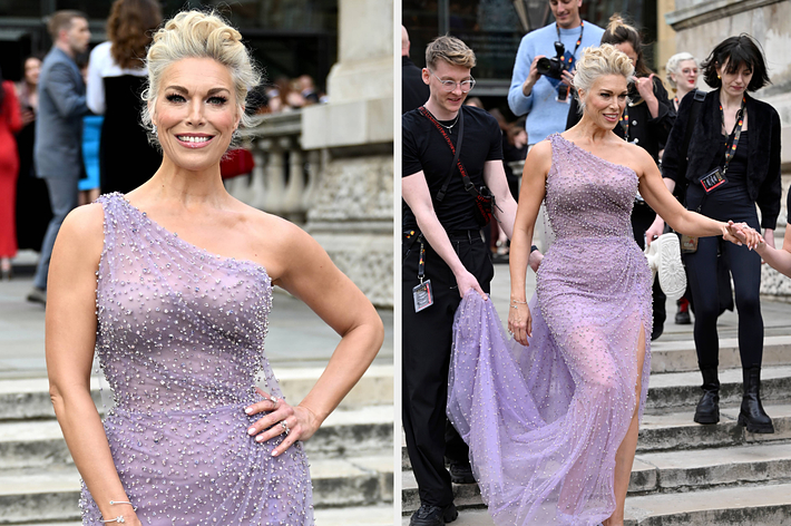 Woman in a beaded lilac gown with a sheer train on a carpeted area, posing for cameras