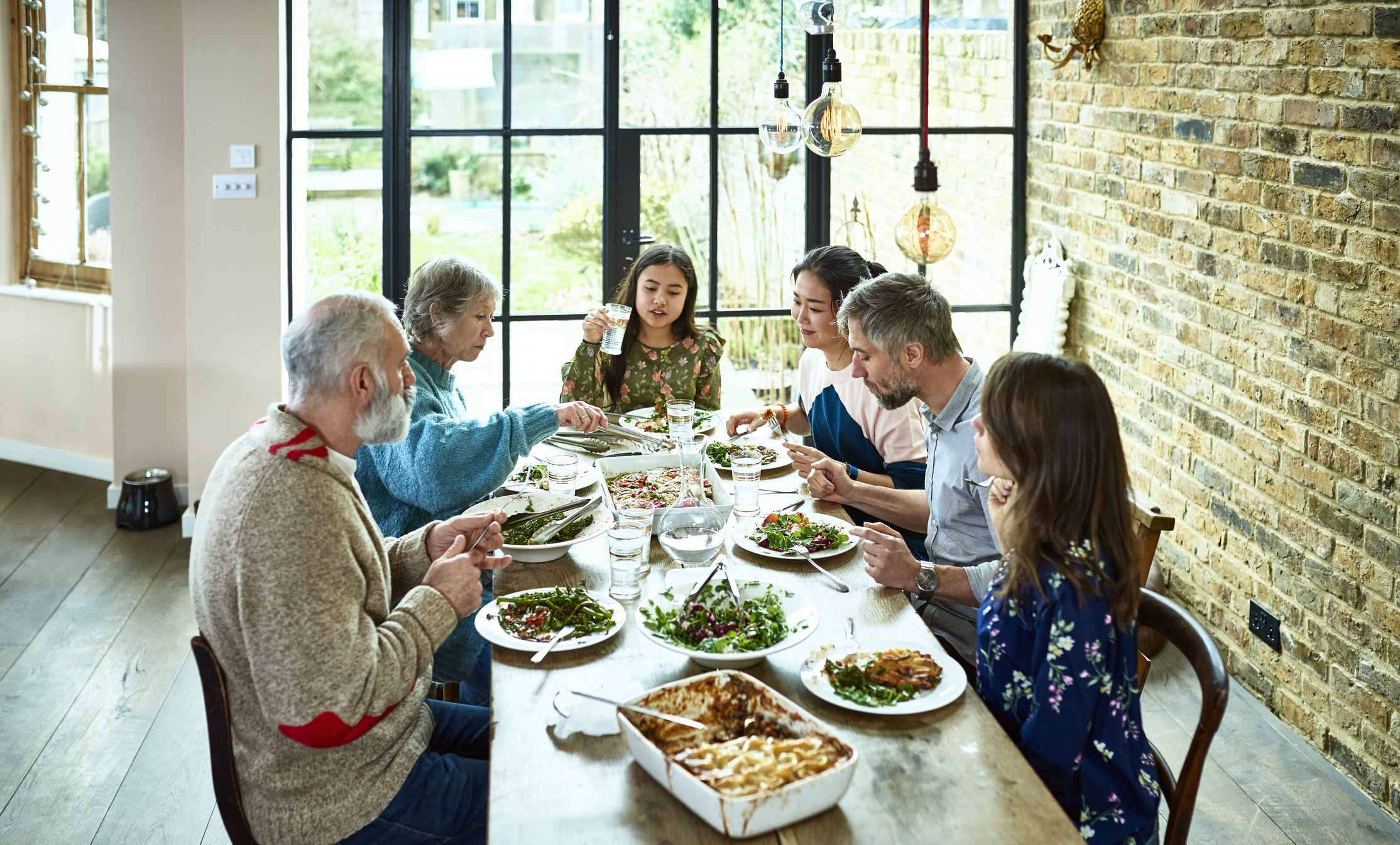 Family of six enjoying a meal together at a dining table