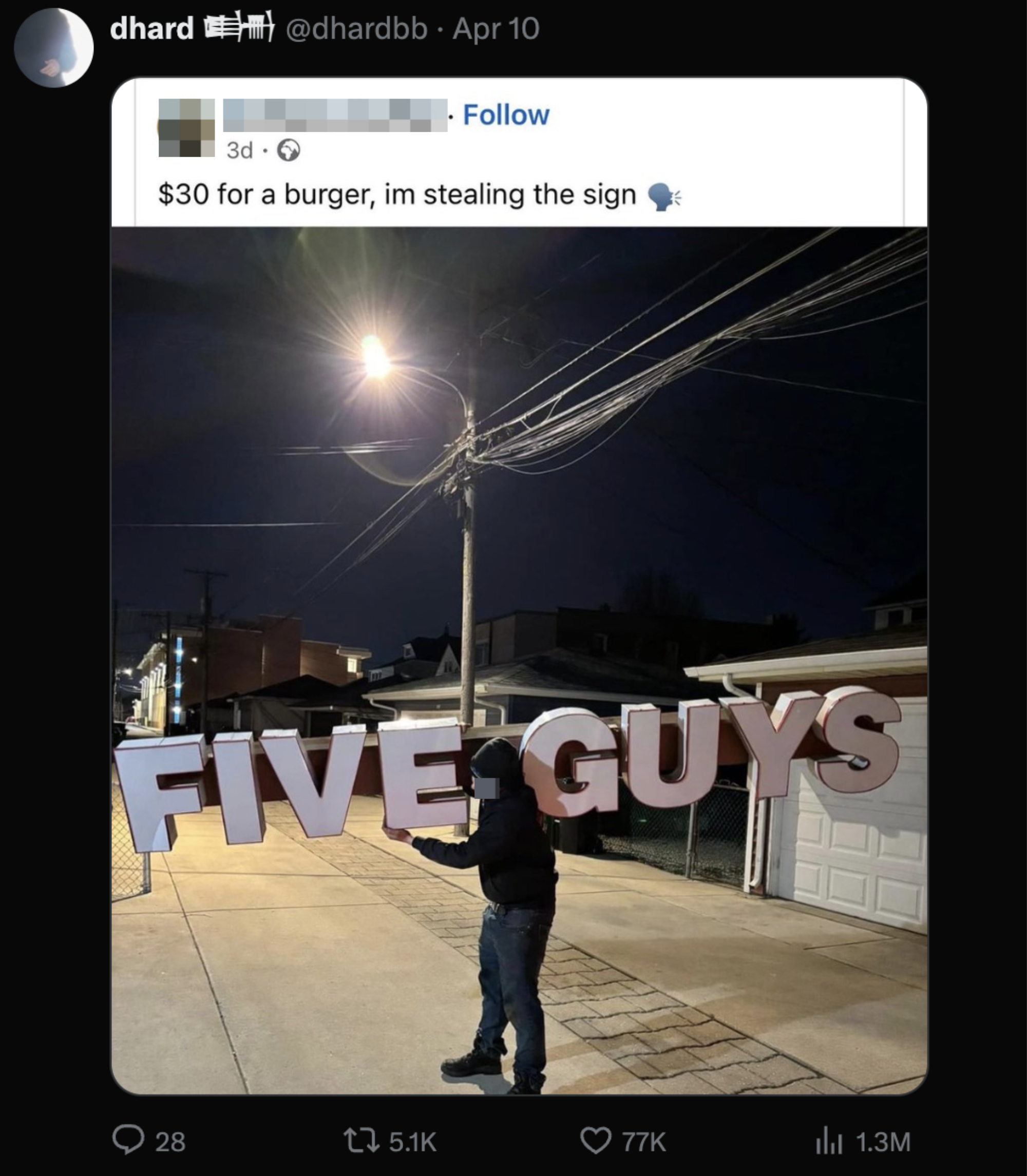 Person holding a large &quot;FIVE GUYS&quot; sign at night on a street