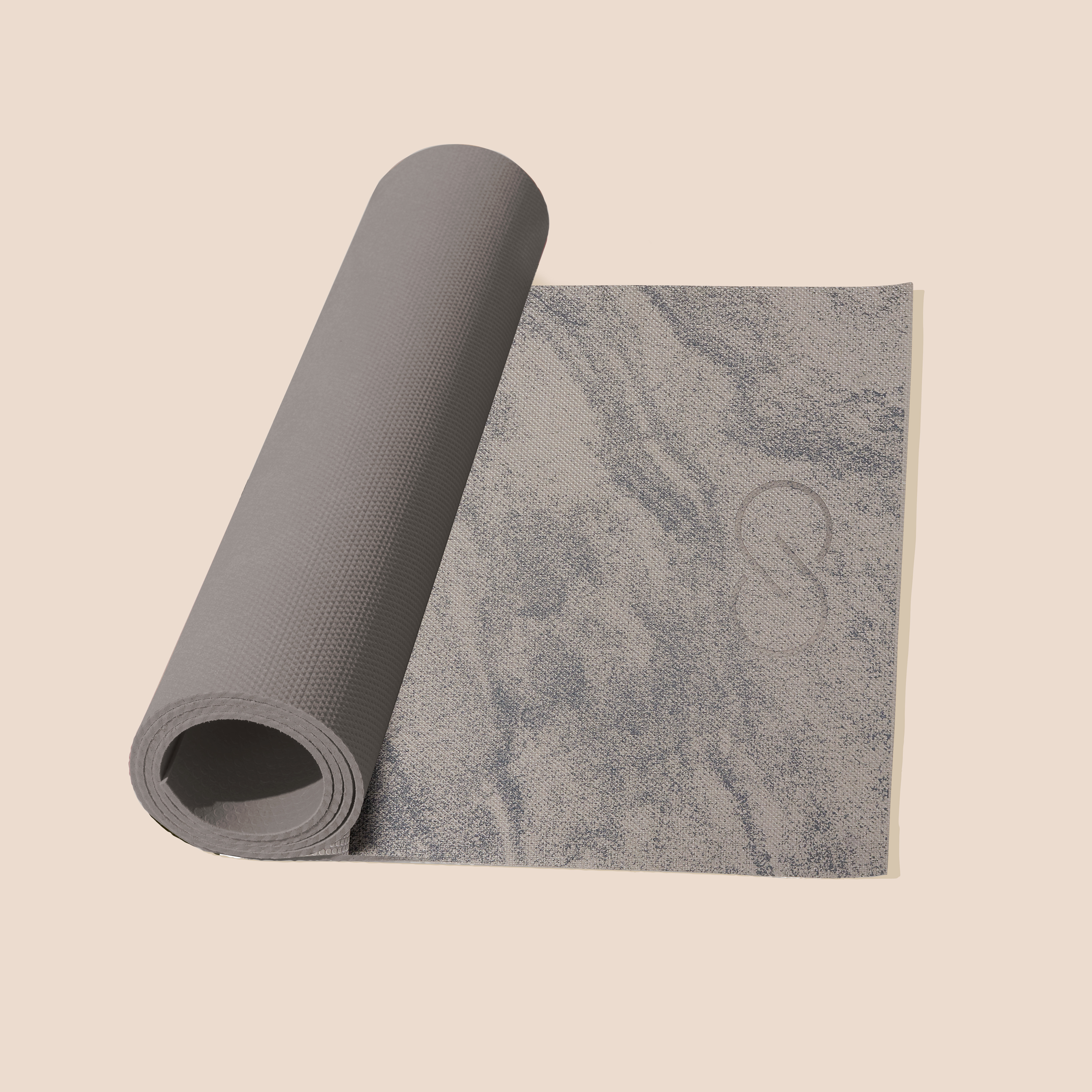 Two rolled yoga mats on a textured floor, one partially unrolled revealing a pattern. Ideal for fitness enthusiasts