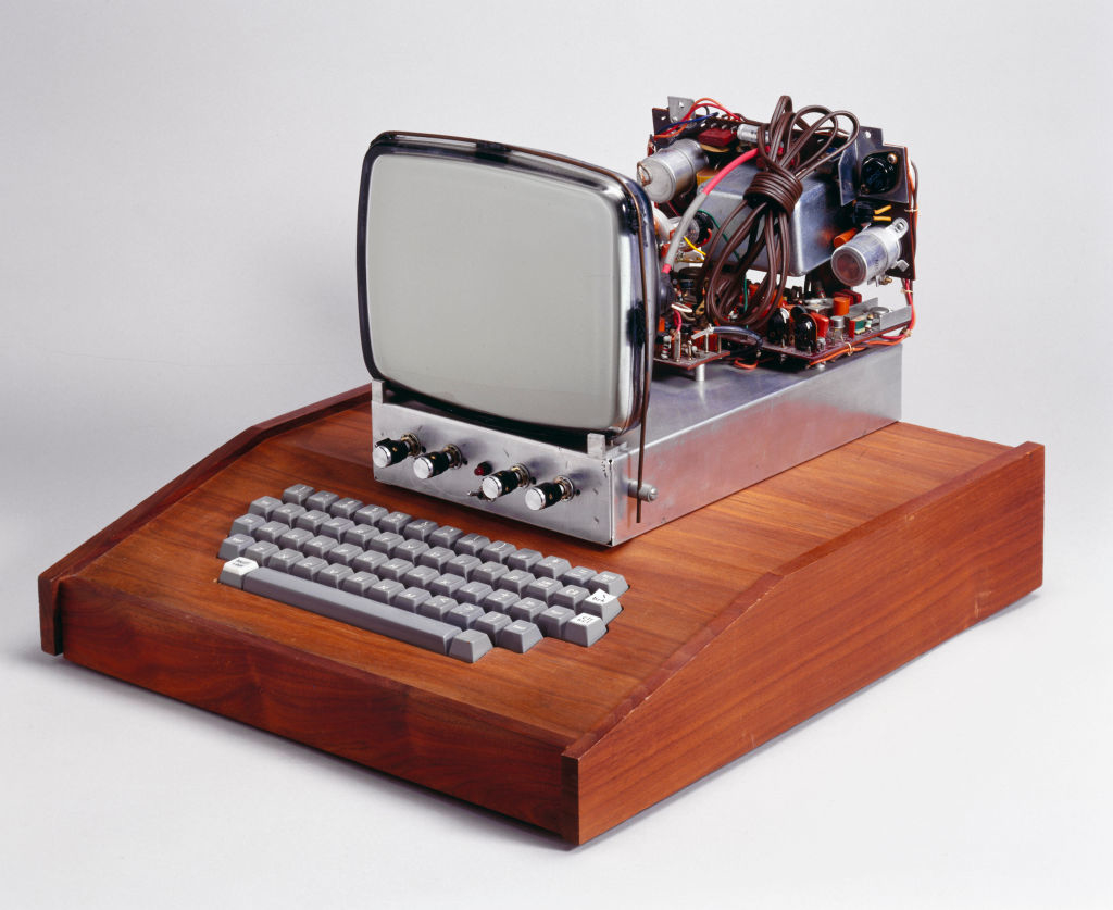 Vintage computer prototype with exposed components and keyboard on a wooden base