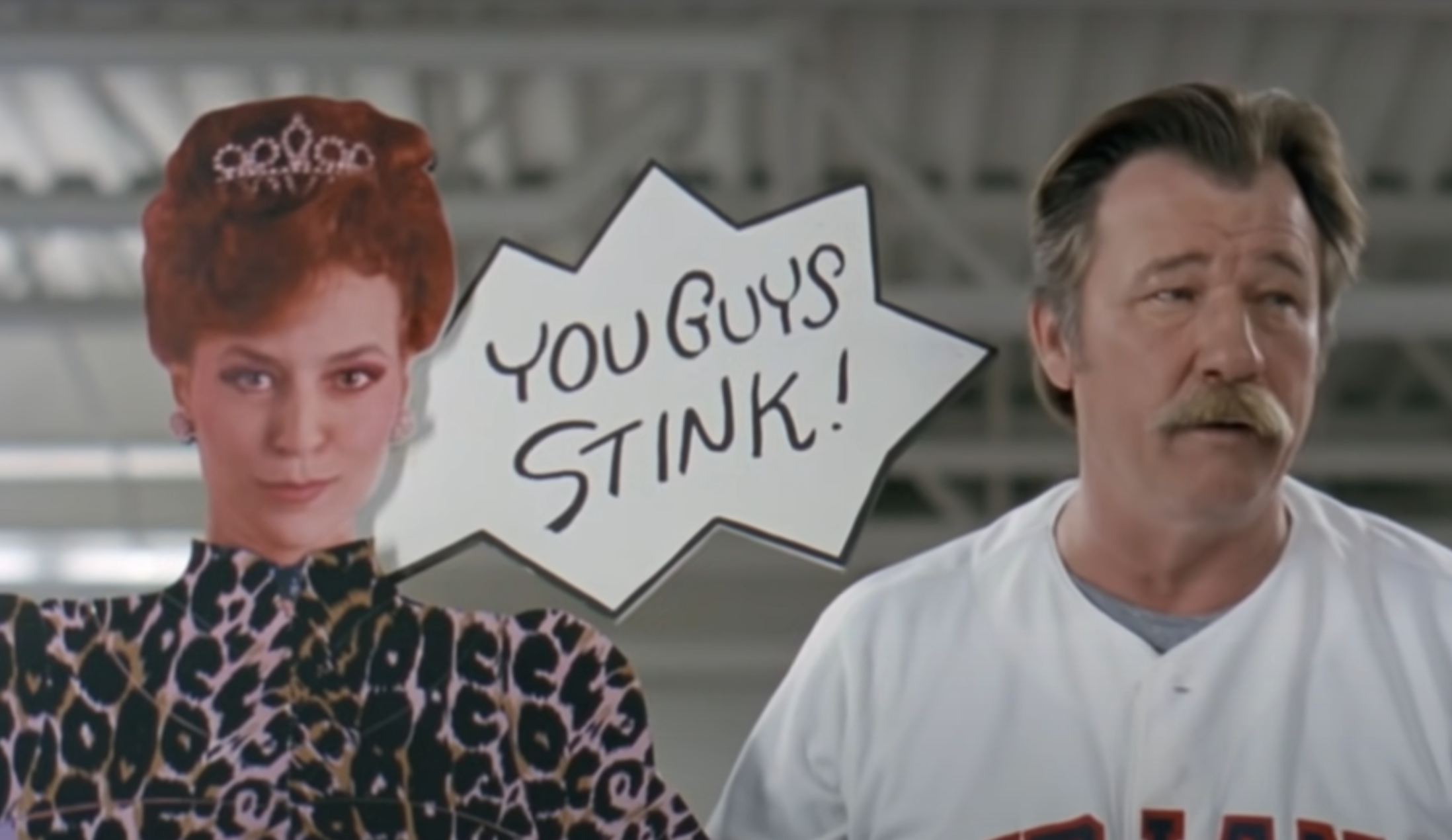 A cardboard cutout of a woman with a comic bubble saying &quot;You guys stink!&quot; next to a man with a mustache in a baseball uniform
