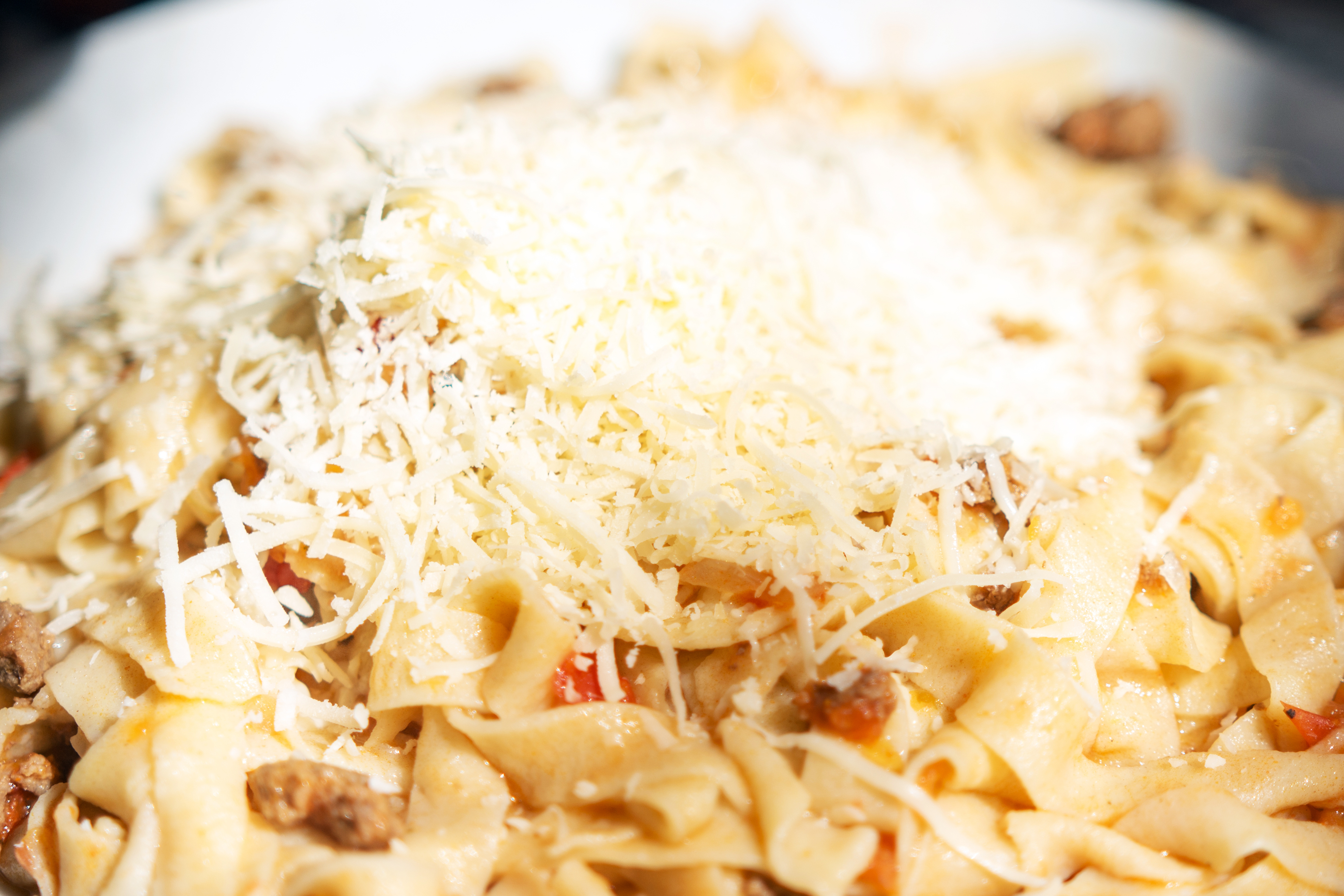 Close-up of a plate of pasta topped with grated cheese