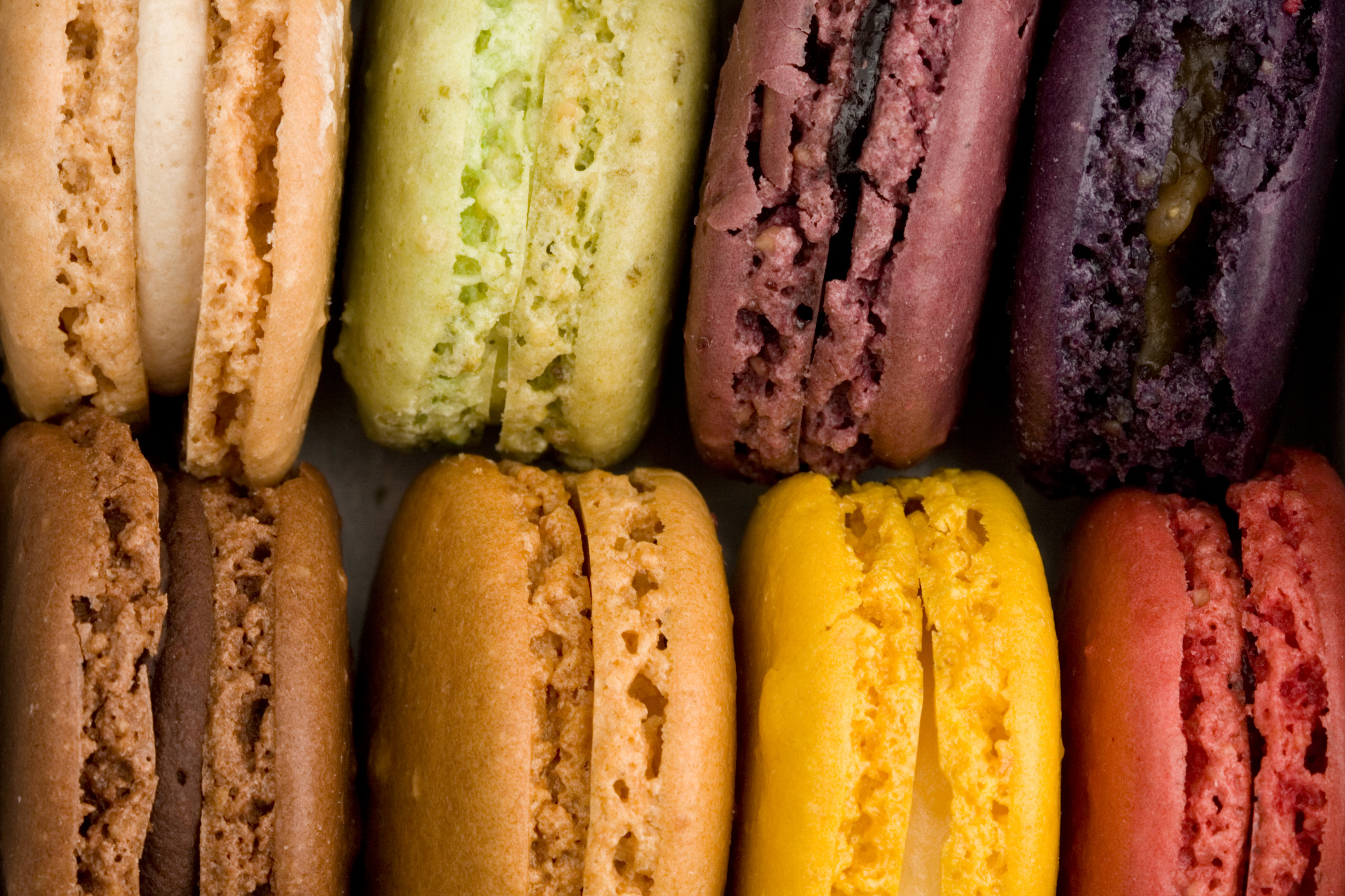 Assorted macarons arranged in two rows, displaying different flavors