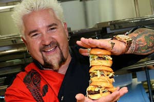 Guy Fieri holding hamburgers