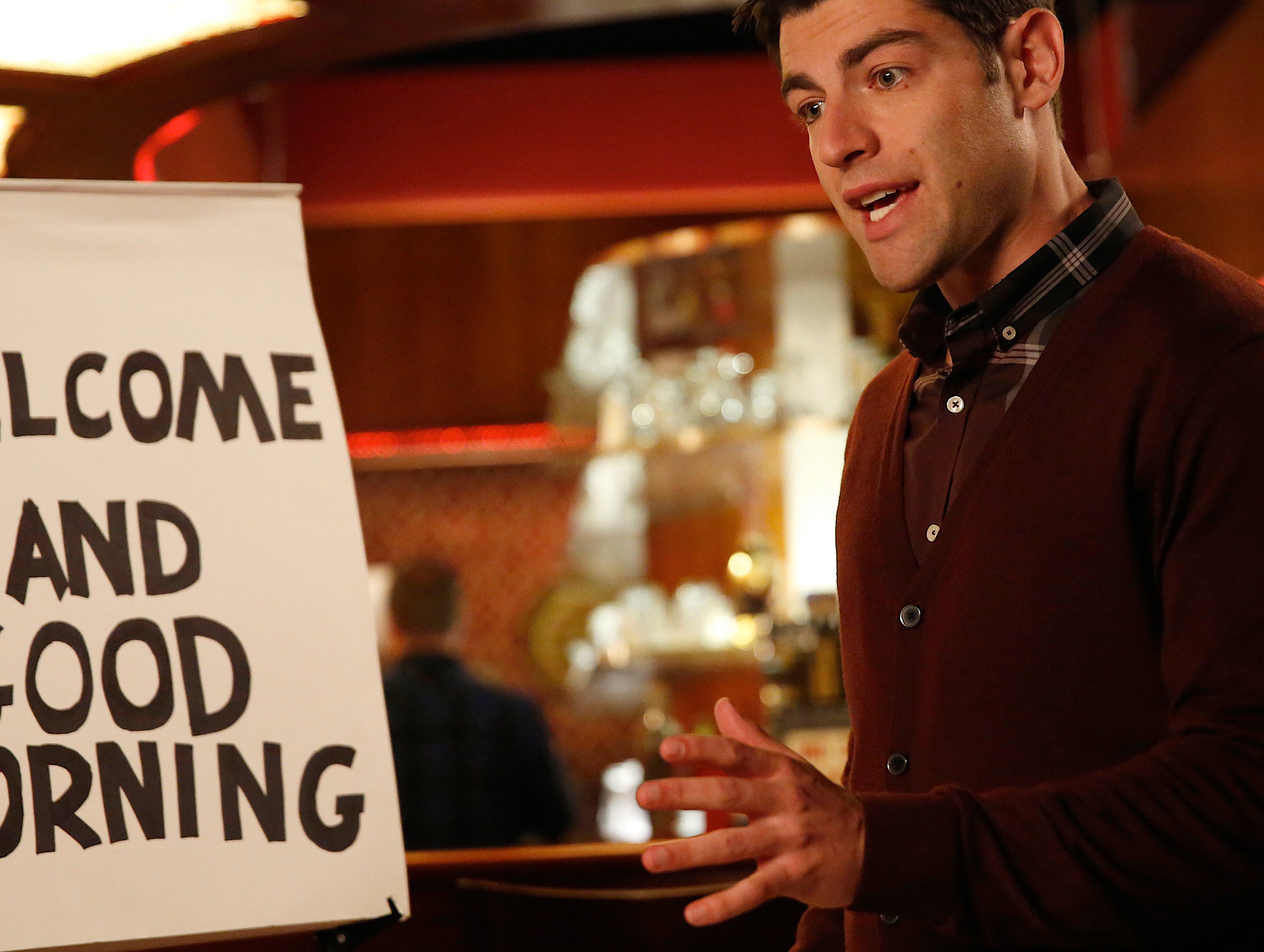 Man standing in a room with a sign saying &quot;WELCOME AND GOOD MORNING.&quot;