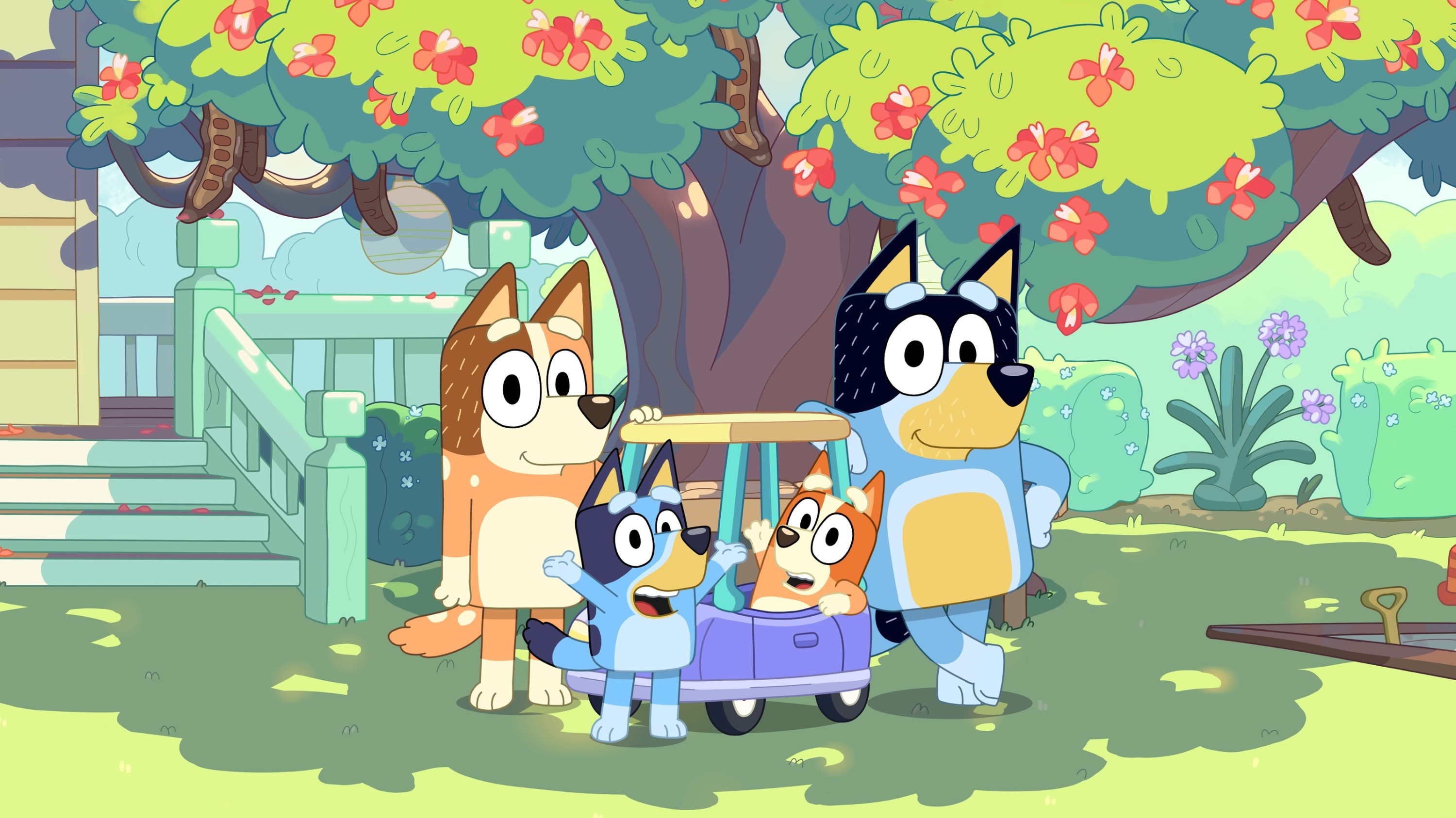 Animated canine family from &quot;Bluey&quot; with parents and children near a toy wagon under a tree