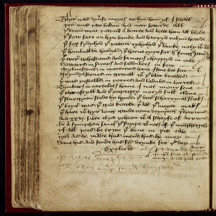 Ancient manuscript page with dense, handwritten text and some faded notes in the margins