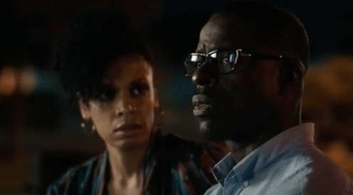 Two characters in a dramatic scene, man in glasses looking right, woman looking at him concerned