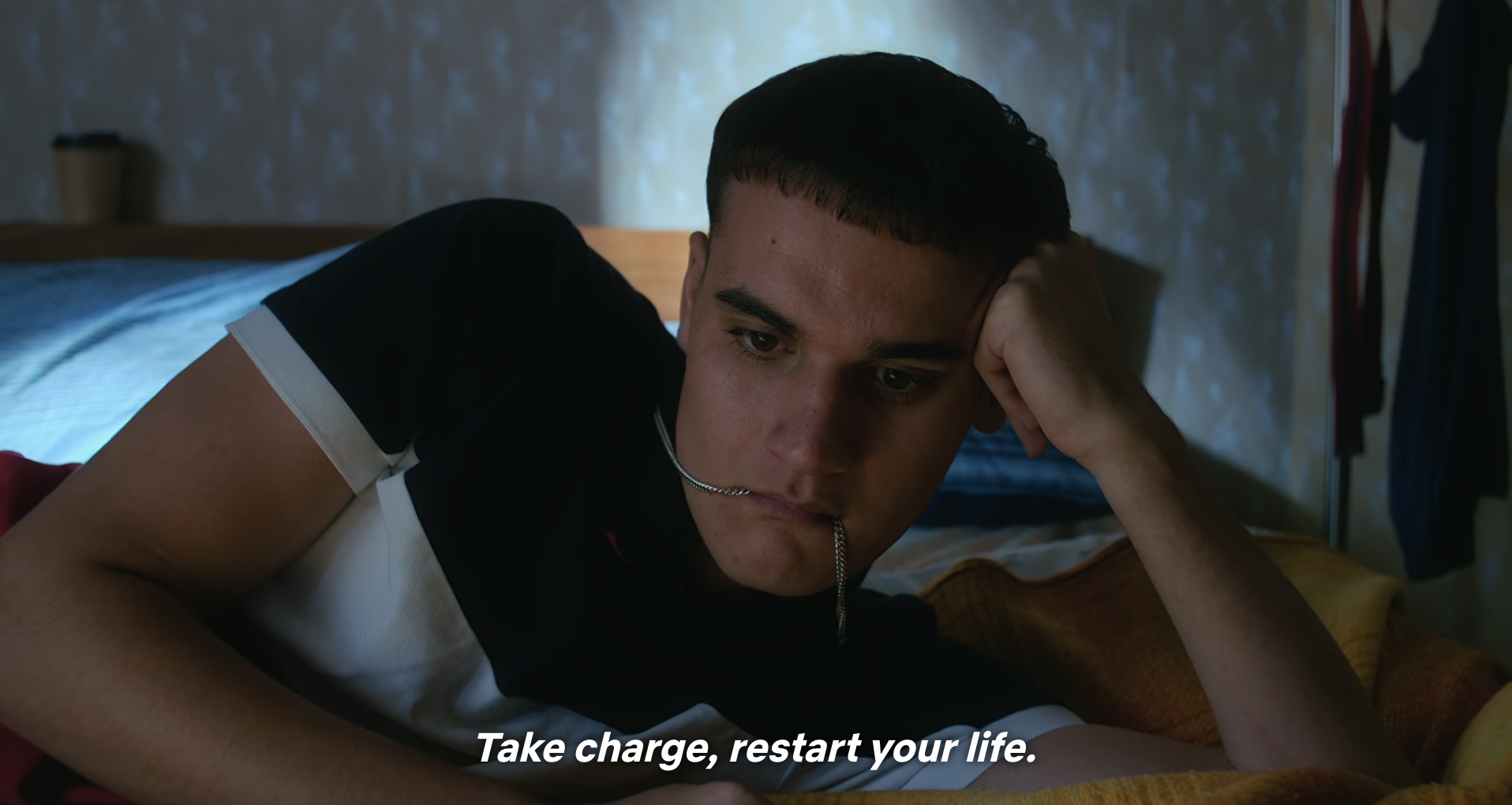 Person lying on bed with a pen in mouth, looking pensive. Text: &quot;Take charge, restart your life.&quot;