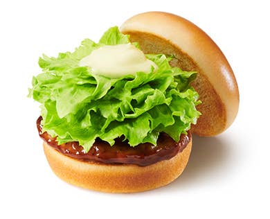 レタスとソースがのったハンバーガーが白い背景にあります。