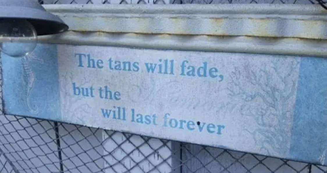 Sign reads &quot;The tans will fade, but the memories will last forever&quot; with part of the text obscured by snow
