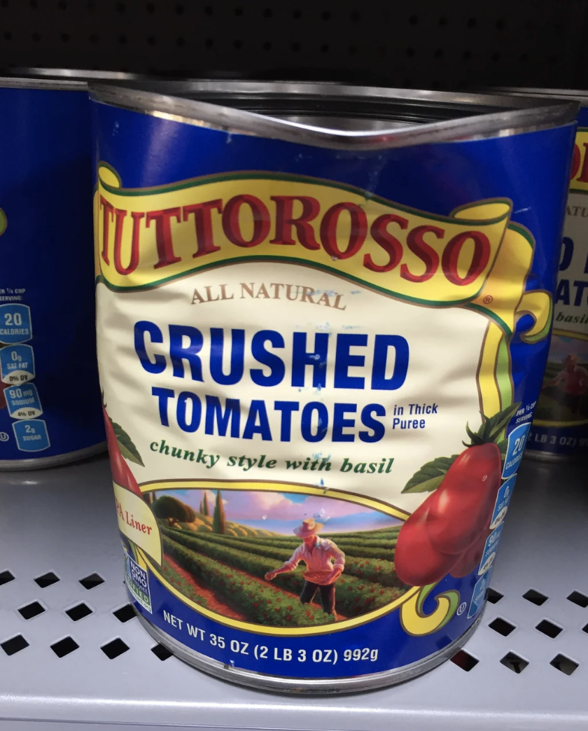 A can of Tuttorosso crushed tomatoes with basil on a shelf