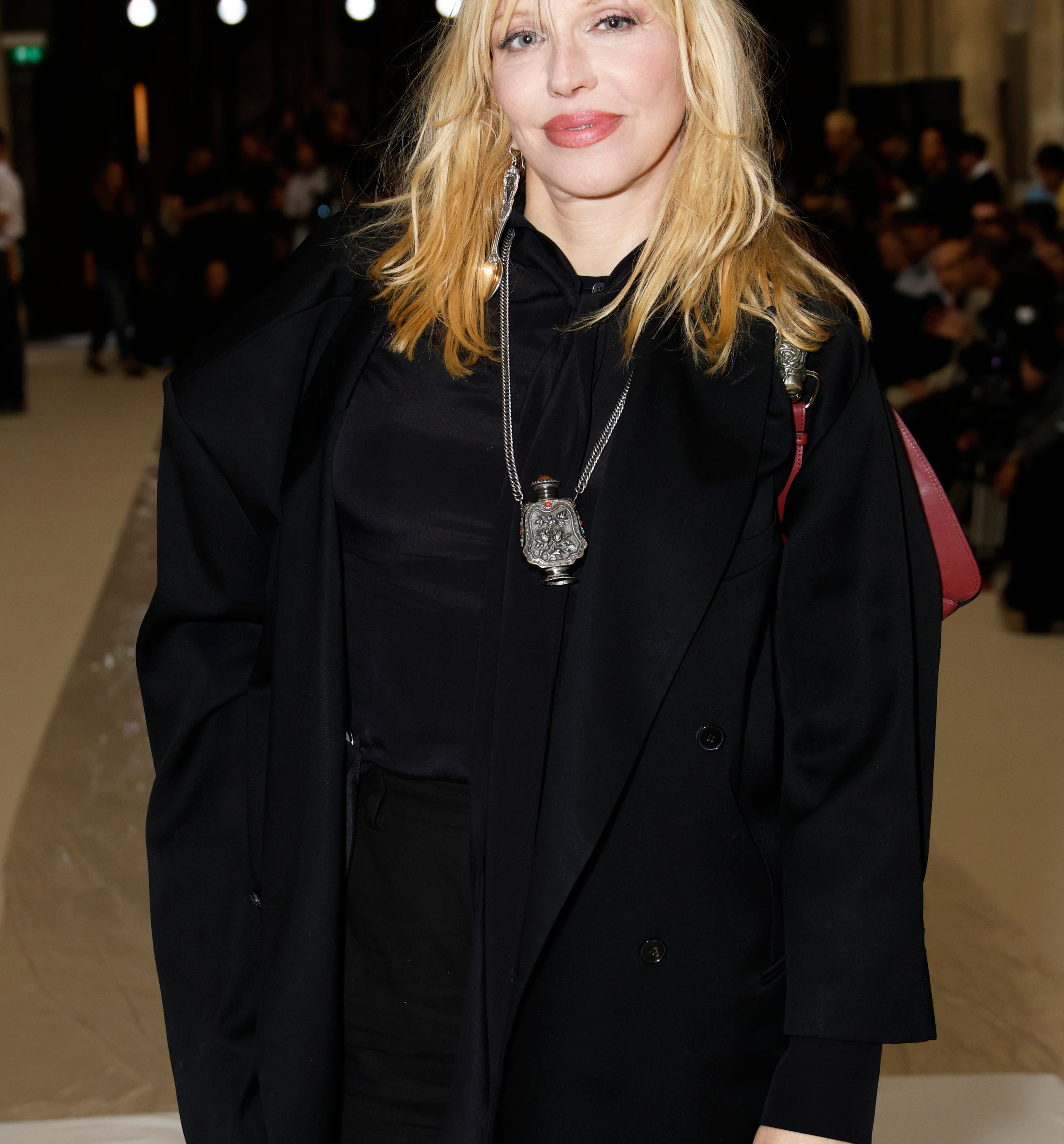 Courtney Love at an event wearing a blazer with a silver pendant