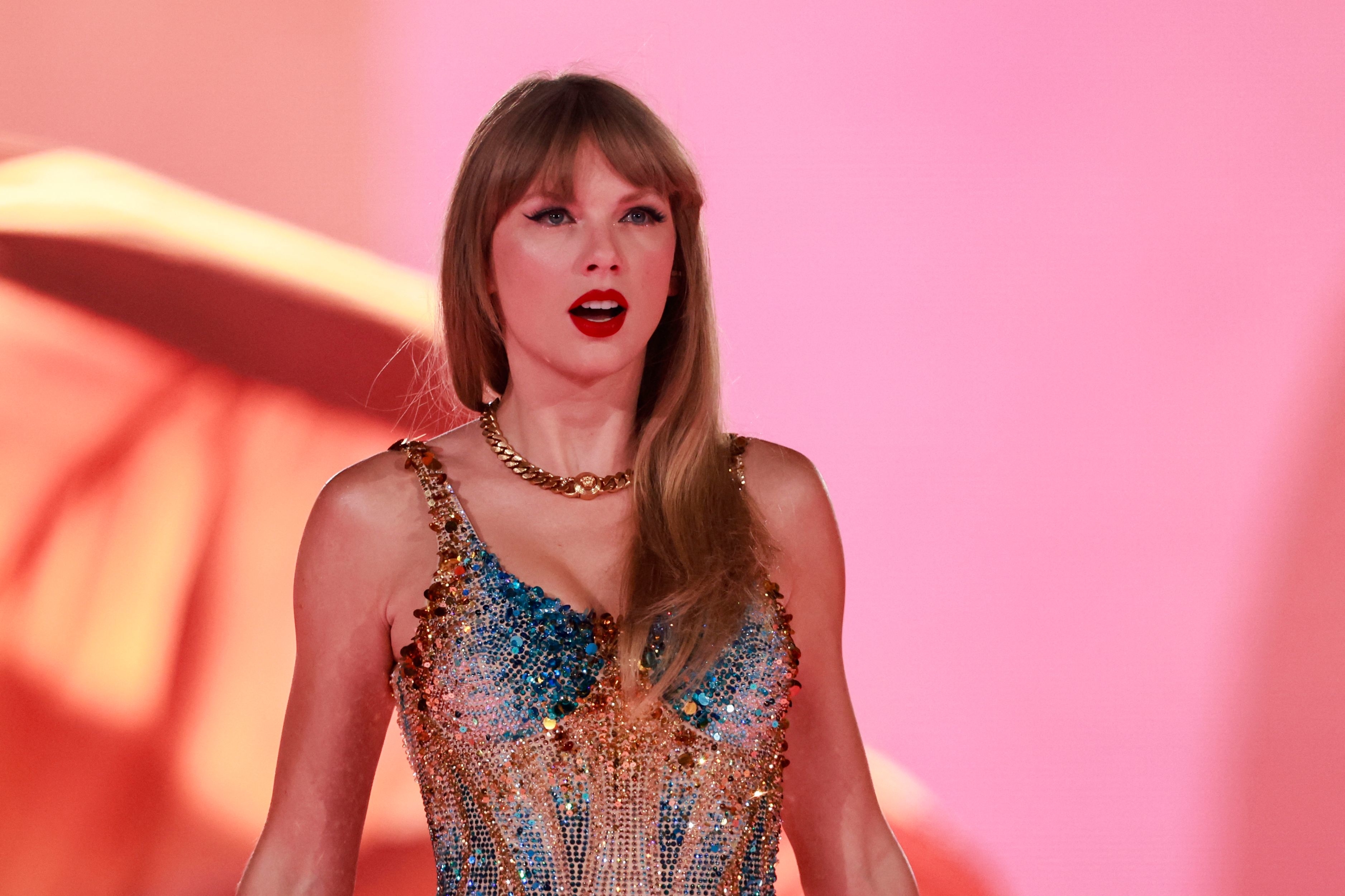 Taylor Swift wearing a sequined dress at on stage