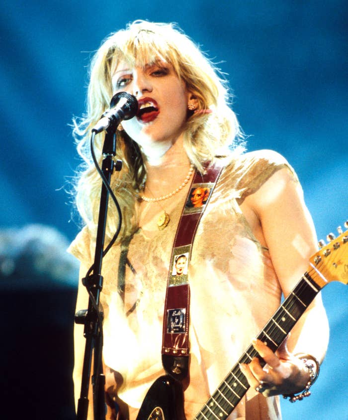 Courtney Love with playing the guitar and singing  on stage