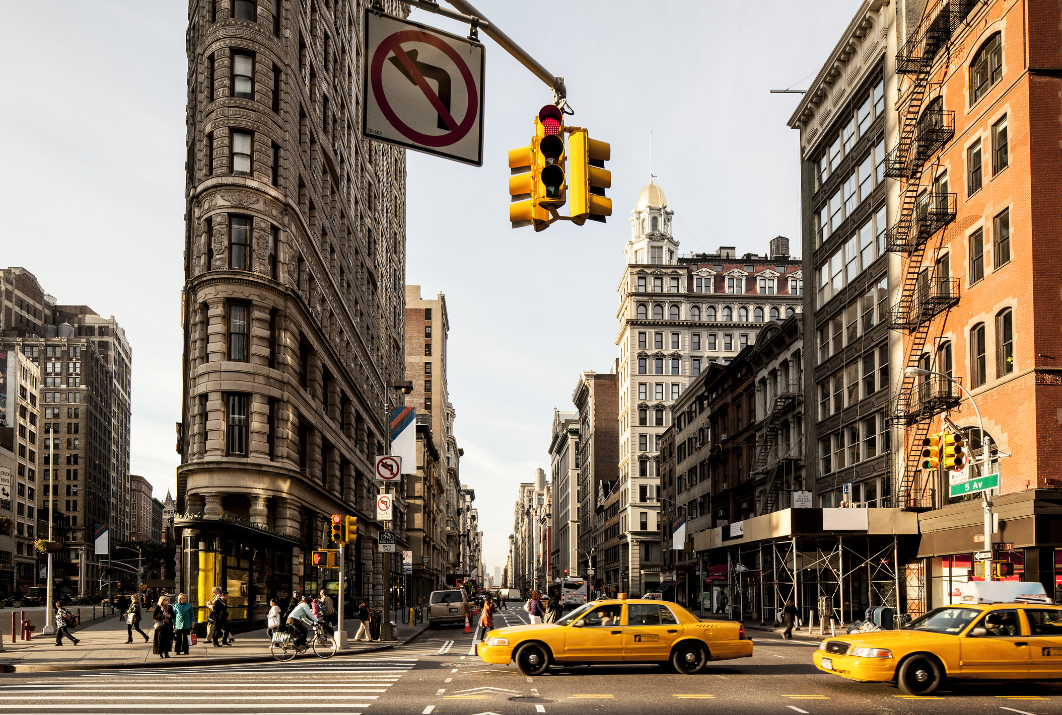 Flatiron Building with traffic lights and yellow cabs at an intersection in New York City