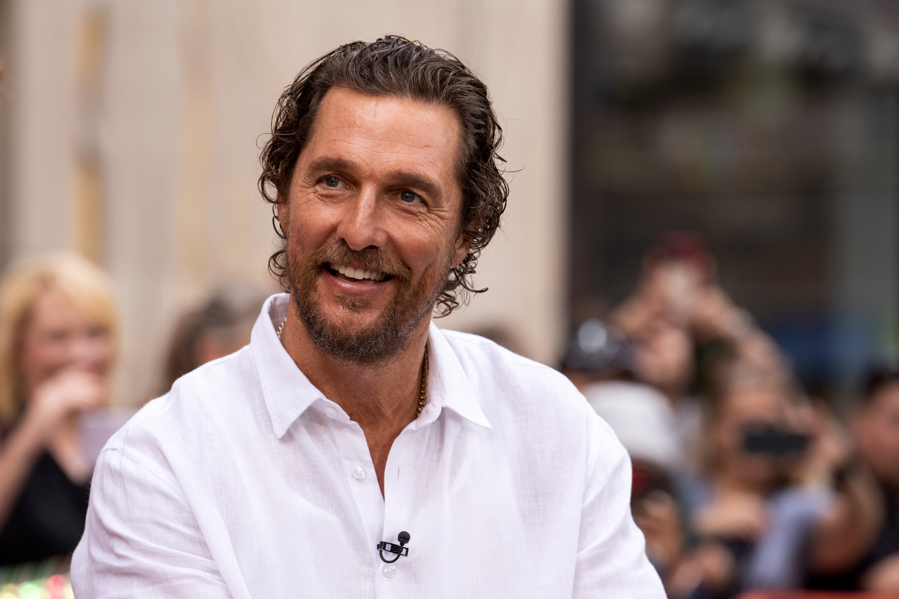 Matthew McConaughey in a shirt smiling during an interview