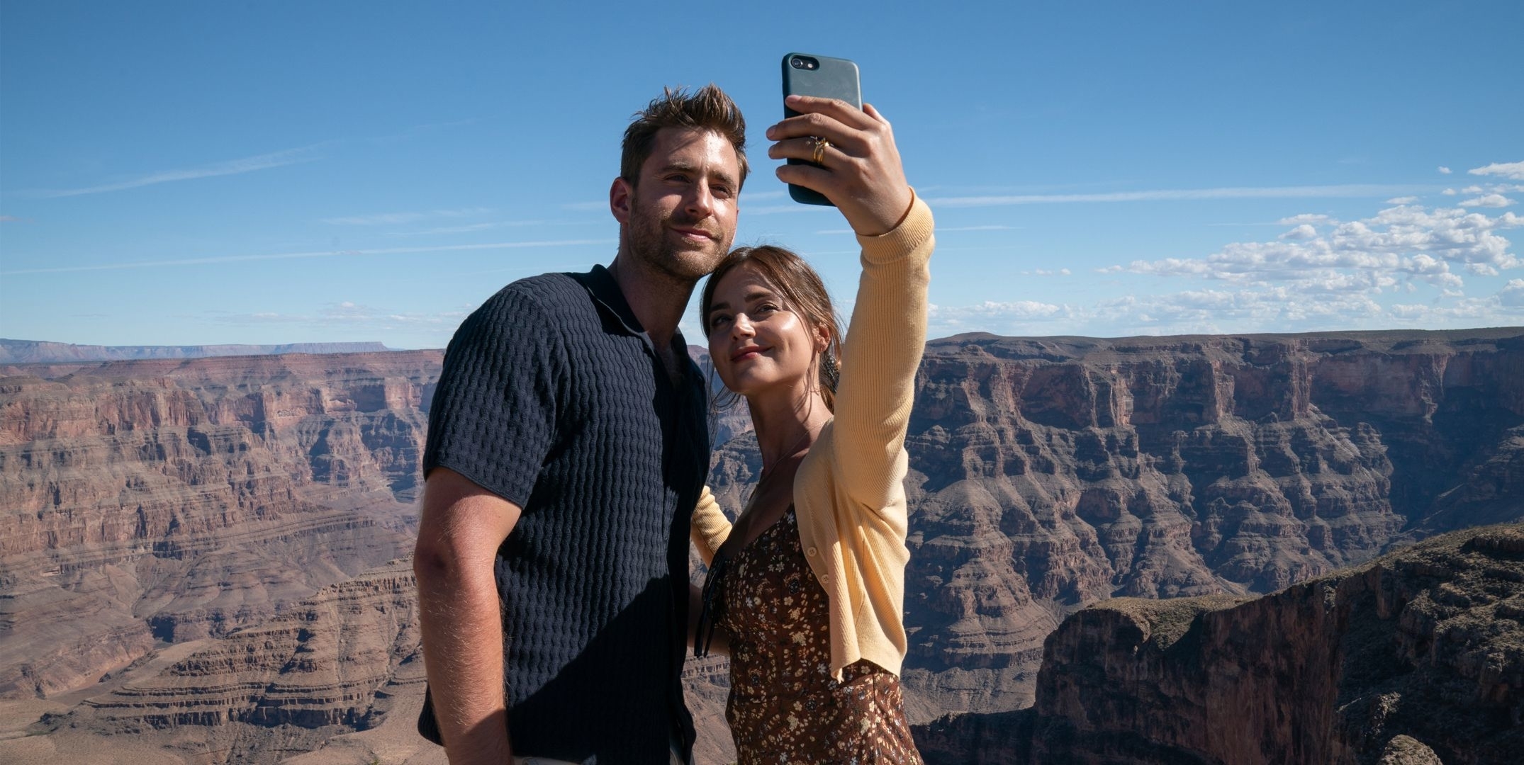 Two people taking a selfie with the Grand Canyon in the background