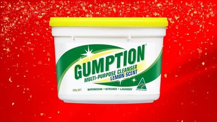 Tub of Gumption multi-purpose cleanser with lemon scent against a red splattered background