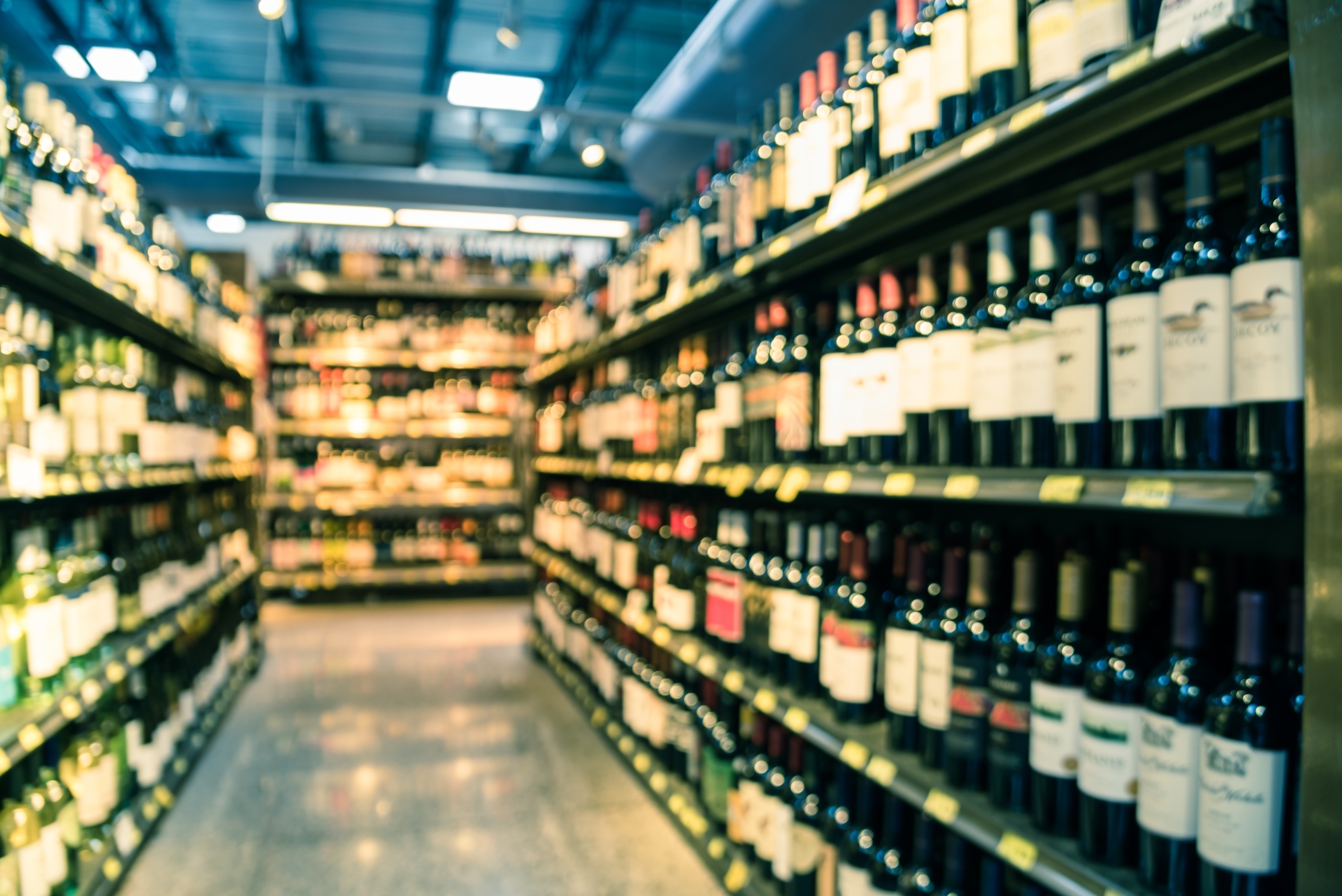 Blurred image of supermarket wine shelves, focus on the concept of choice and abundance
