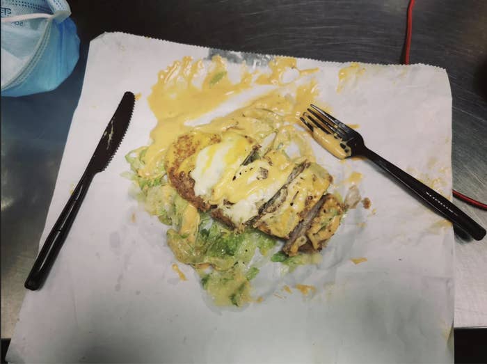 Photo of a microwaved chicken and egg dish on a table, fork and knife on either side