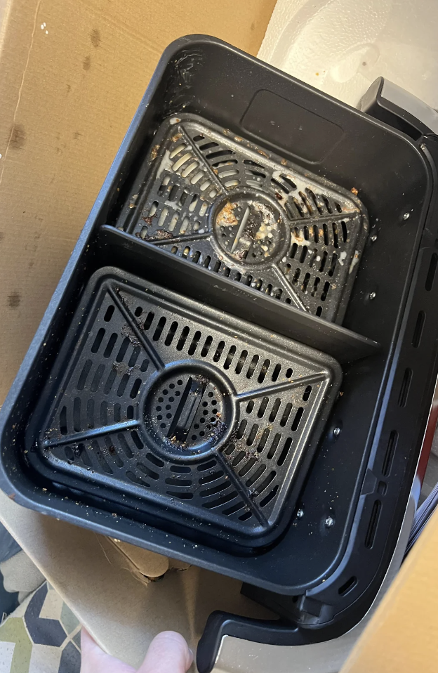 Black stove-top burners soaking in a container, displaying a cleaning hack found online