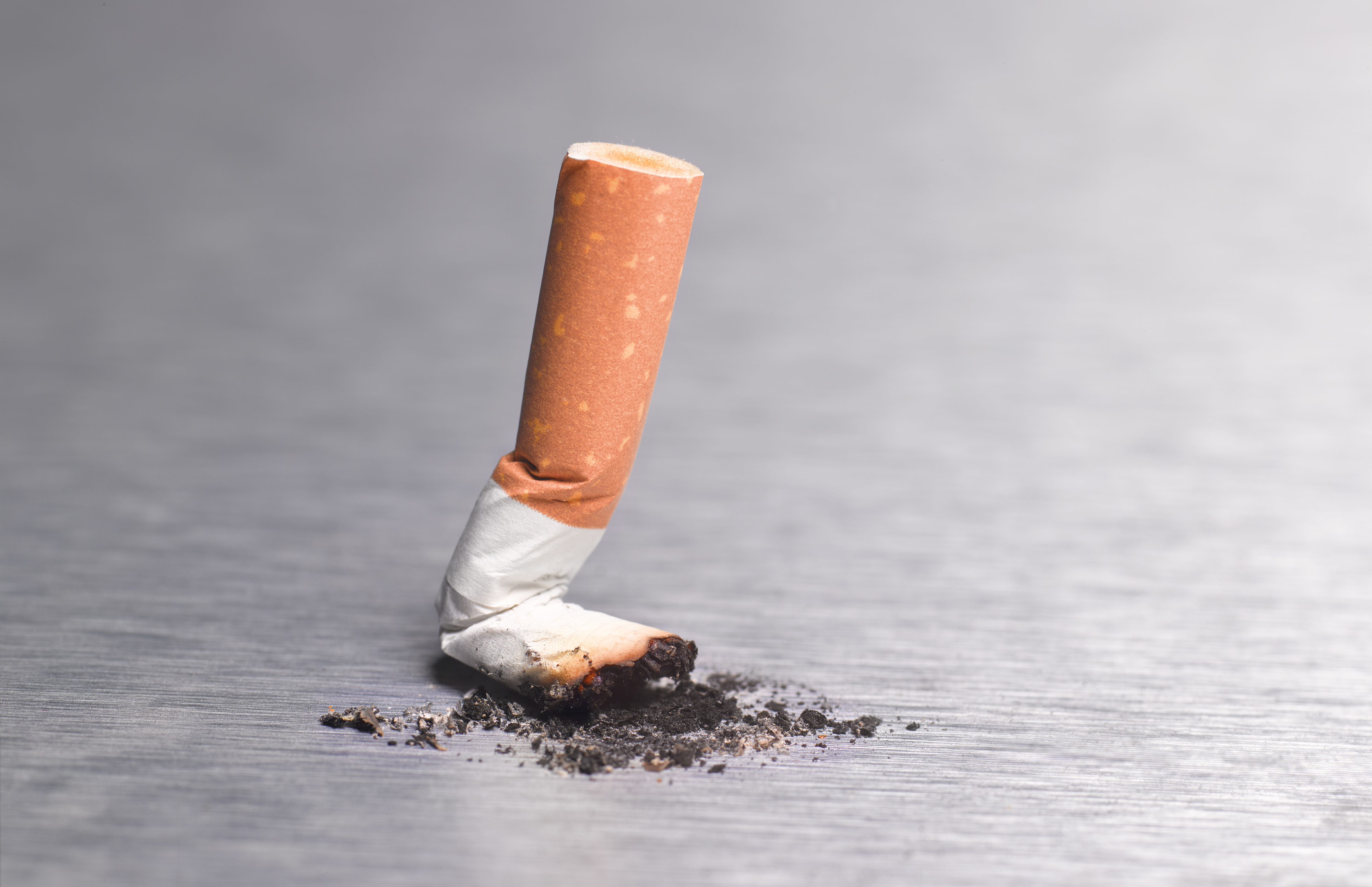 Extinguished cigarette butt on a surface, concept for smoking cessation and health awareness