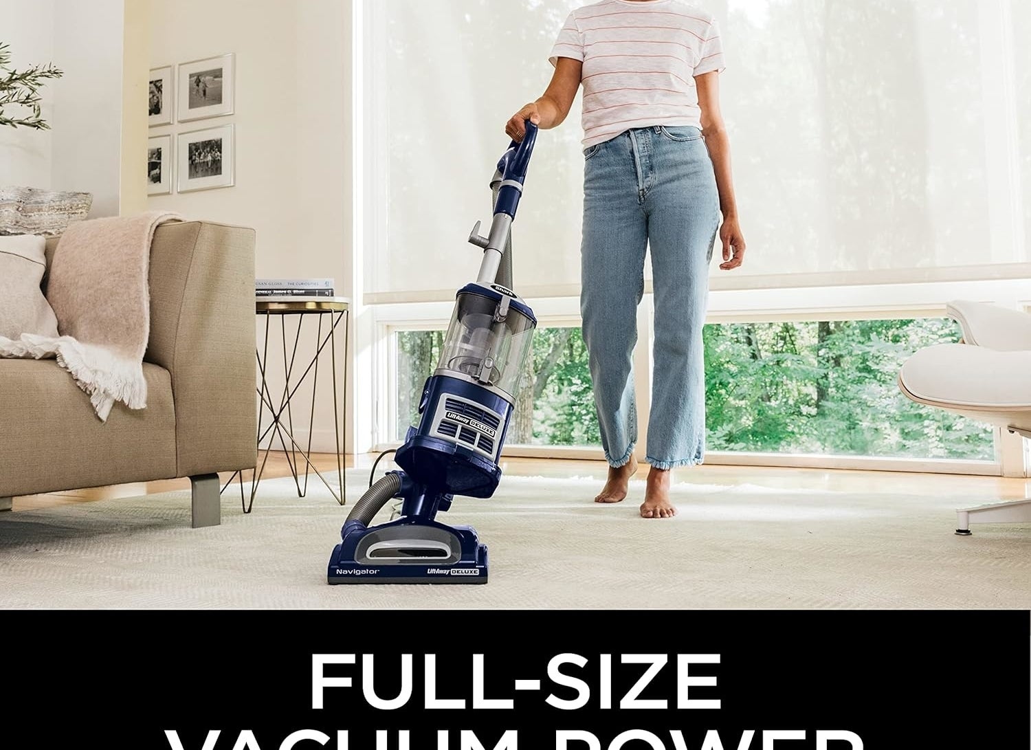 Woman using an upright vacuum cleaner in a bright living room, text highlights full-size vacuum power