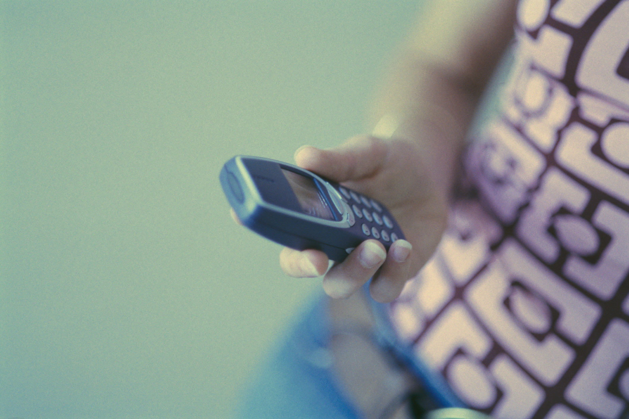 Person holding a vintage Nokia cell phone, indicative of early 2000s technology