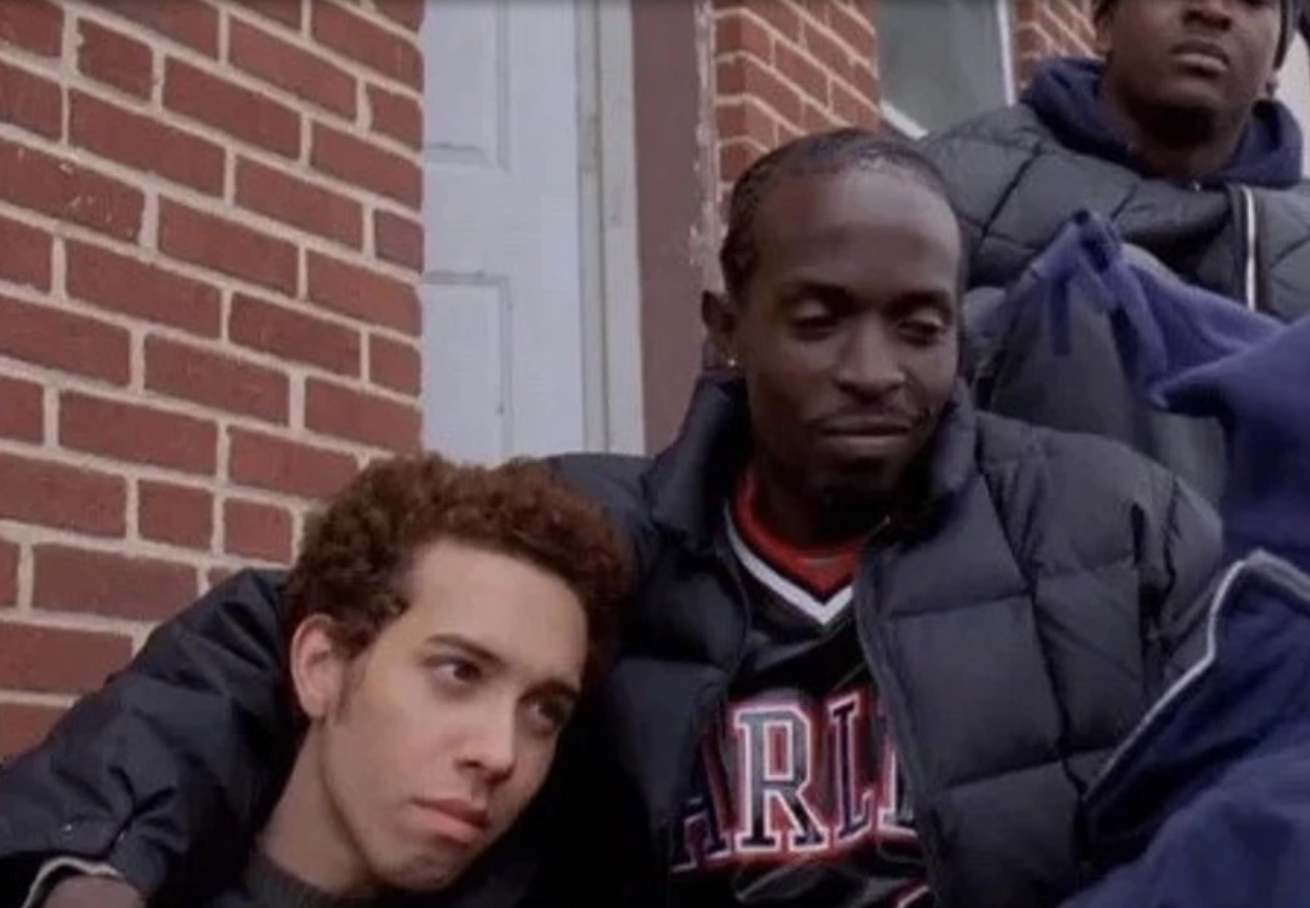 Two characters from the TV show &#x27;The Wire&#x27;, with one resting his head on the other&#x27;s shoulder
