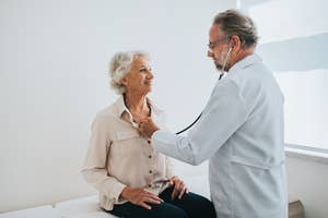 A doctor listens to a senior woman's heartbeat with a stethoscope during a check-up