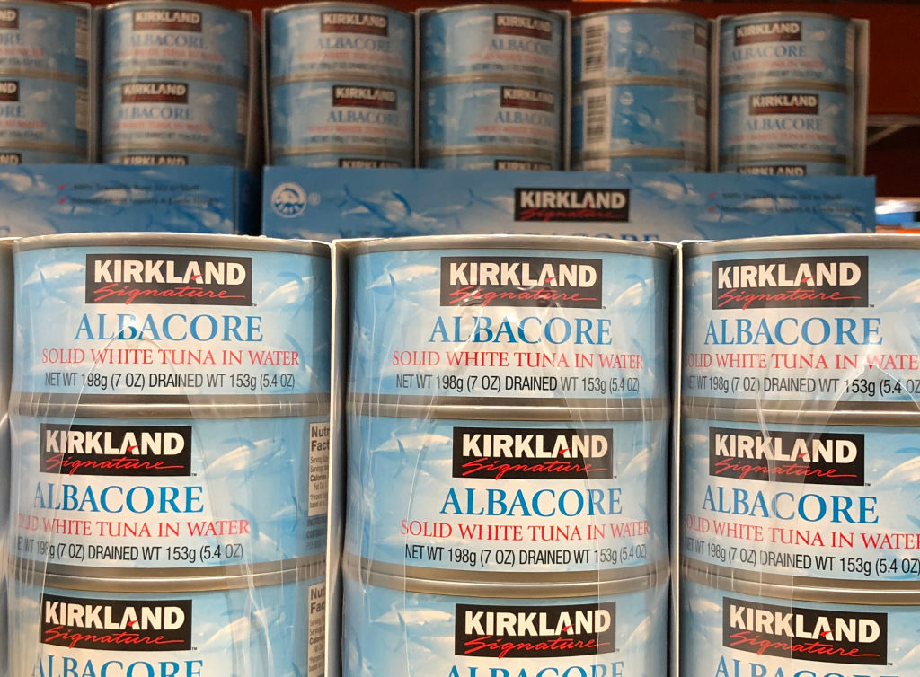 Stacked cans of Kirkland brand albacore tuna on shelves