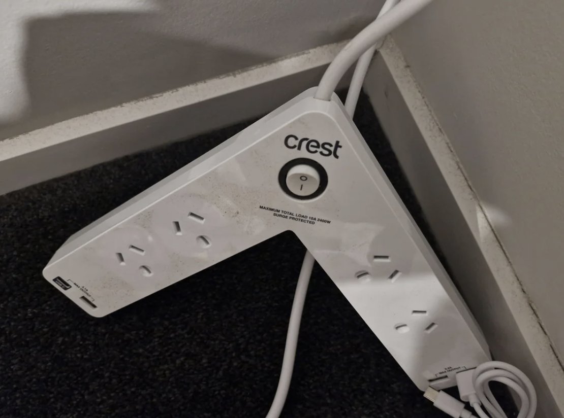 A Crest power board on the floor with plugged-in cables