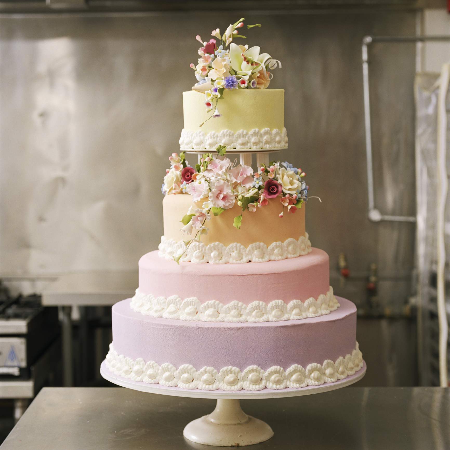 Four-tiered cake with floral decorations on a stand