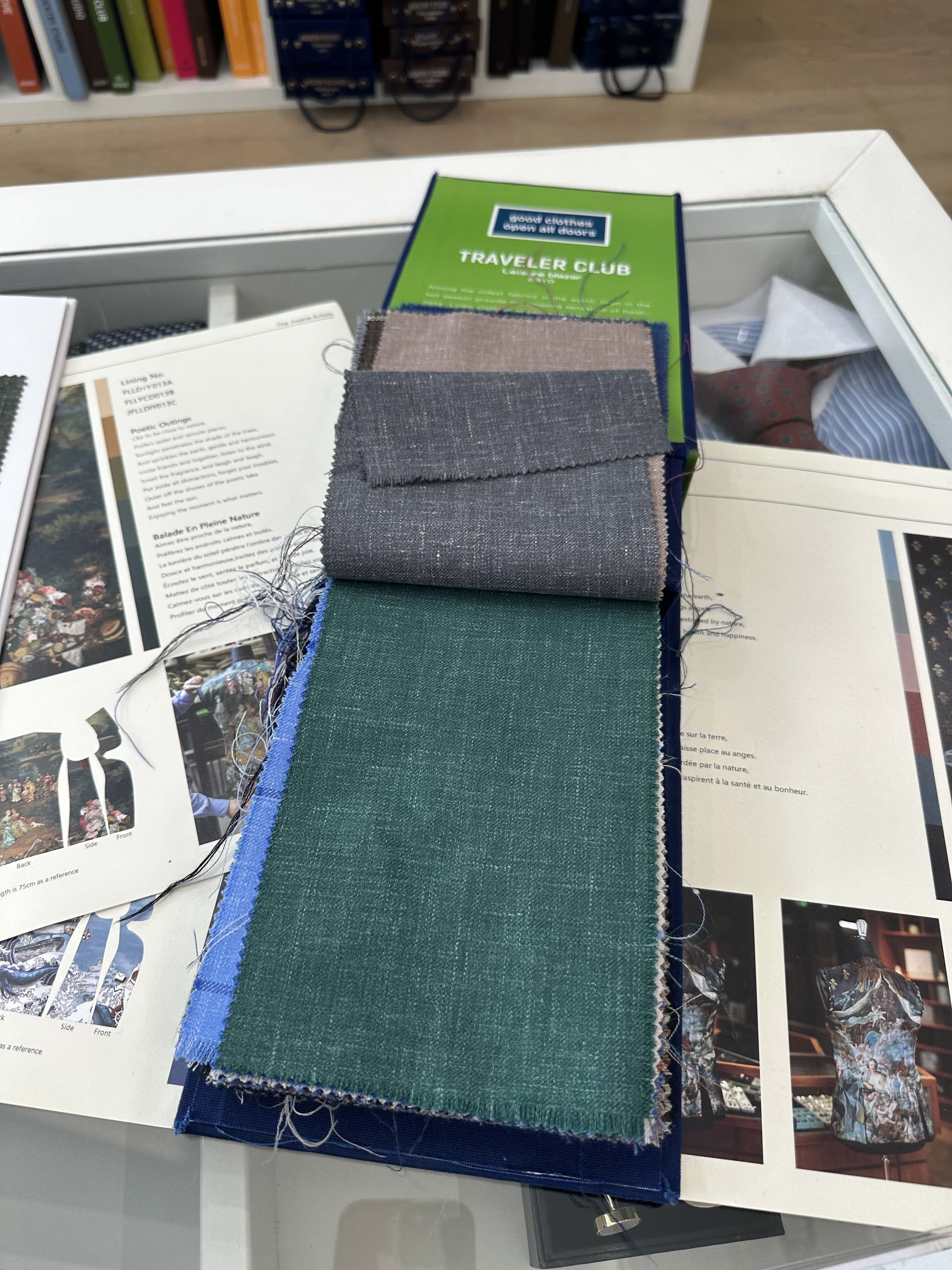 Fabric samples on display, with varying textures and patterns, laid out on a counter above brochures