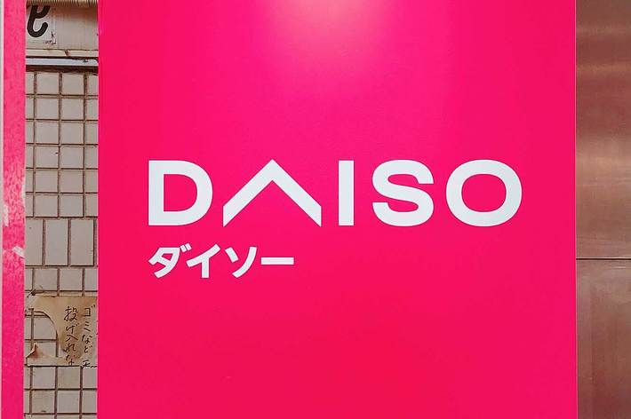 ダイソーのロゴが大きく表示されたピンクの看板