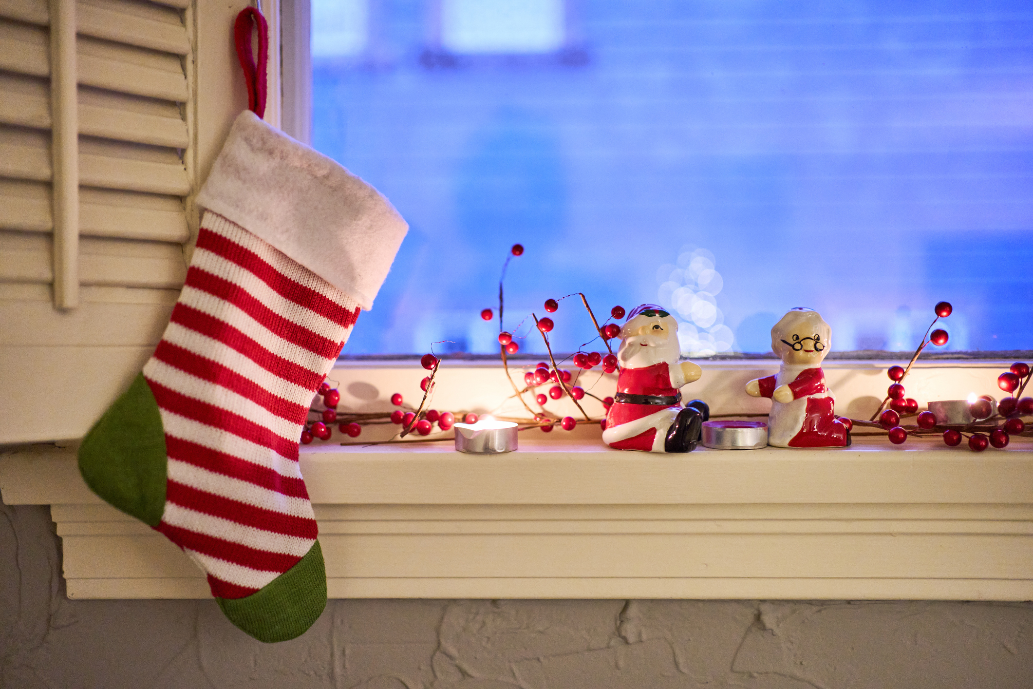 Holiday-themed window sill with a stocking, Santa figurine, and decorative items